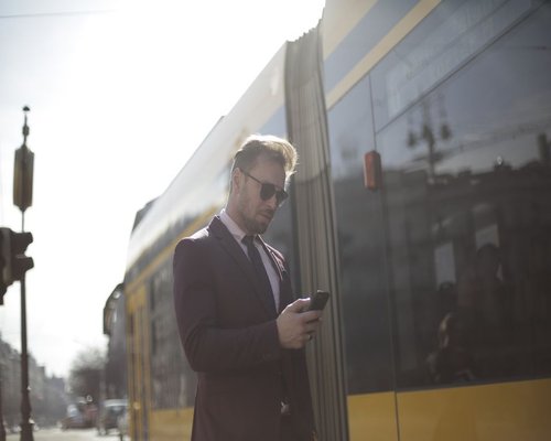 Commuter checking phone on a modern public transit train